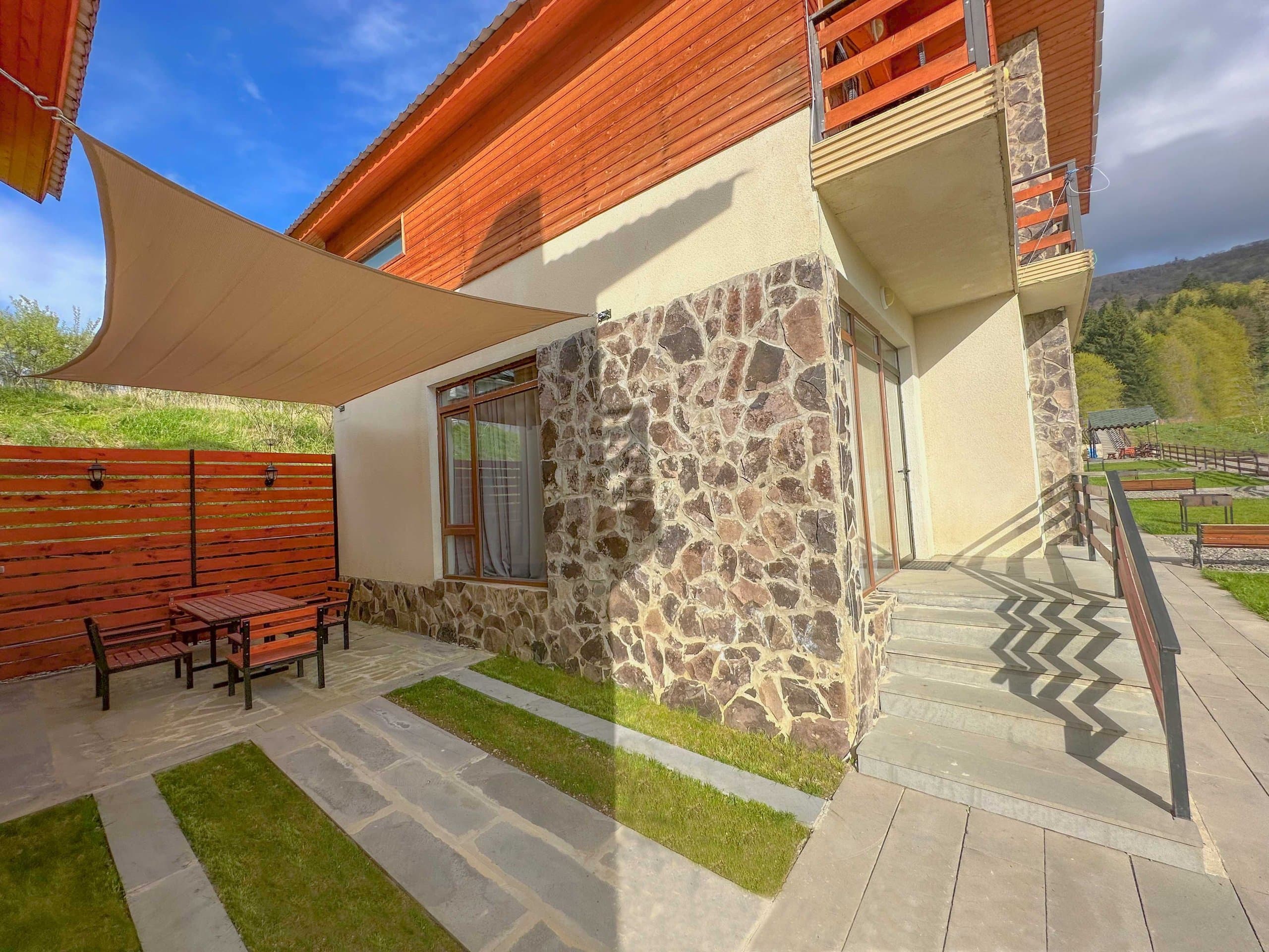 Stone-and-wood mountain villa exterior and patio.