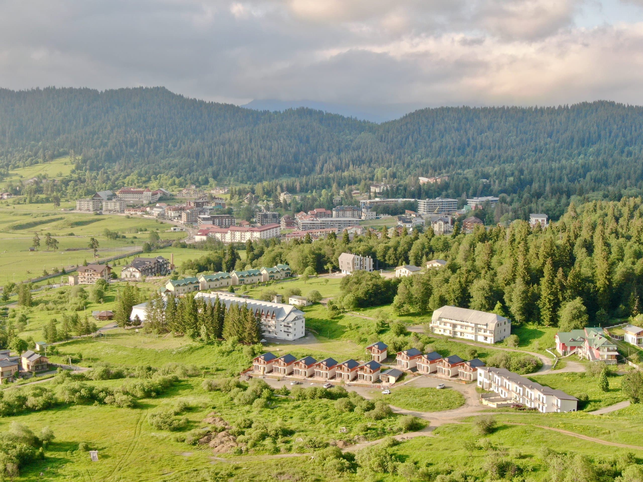 Mountain accommodation area surrounded by green summer scenery.