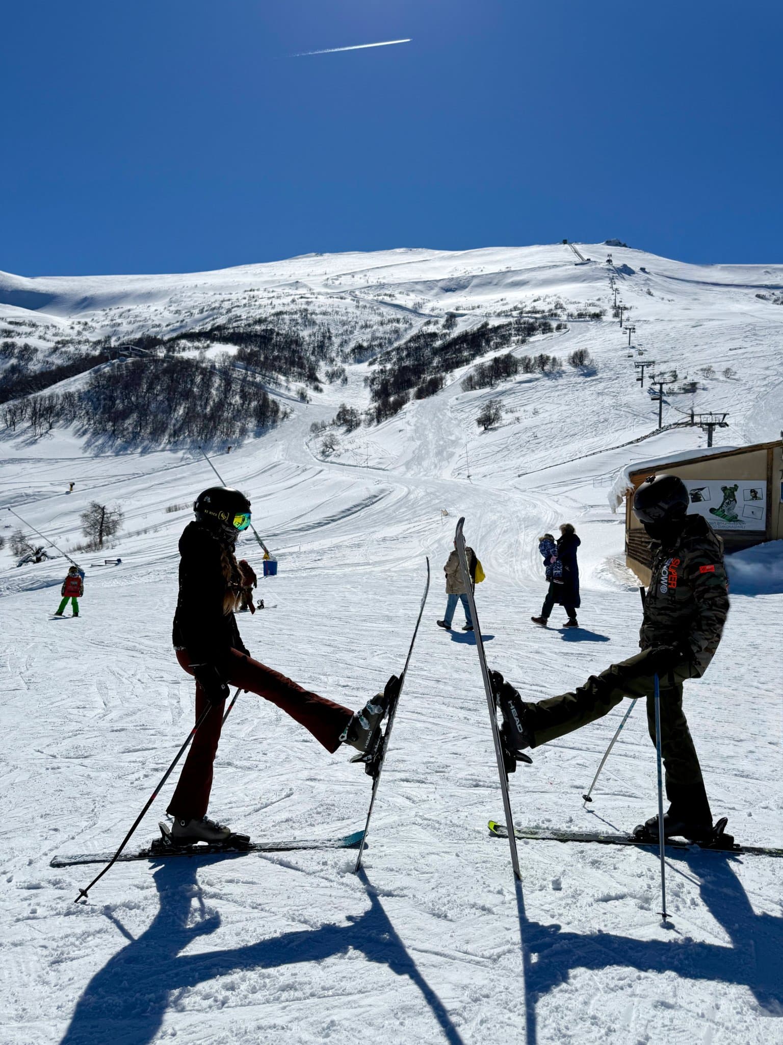 Two skiers standing together on a snowy mountain slope.
