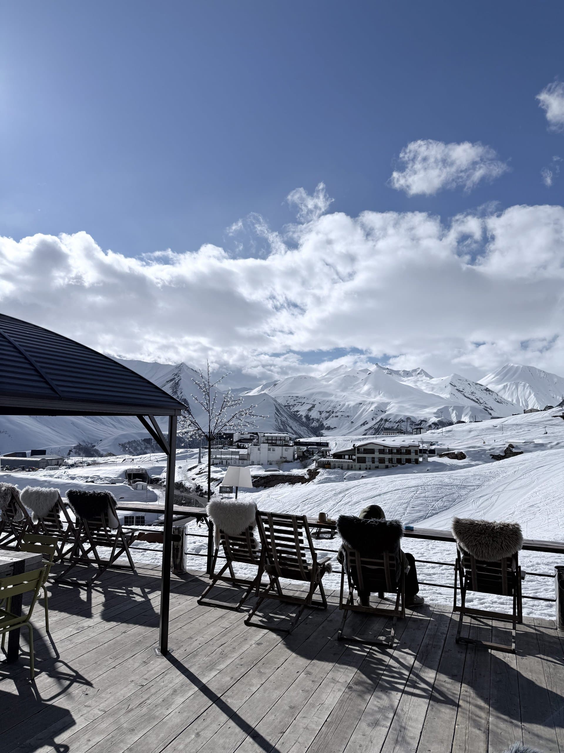 Mountain terrace overlooking snow-covered ski slopes.