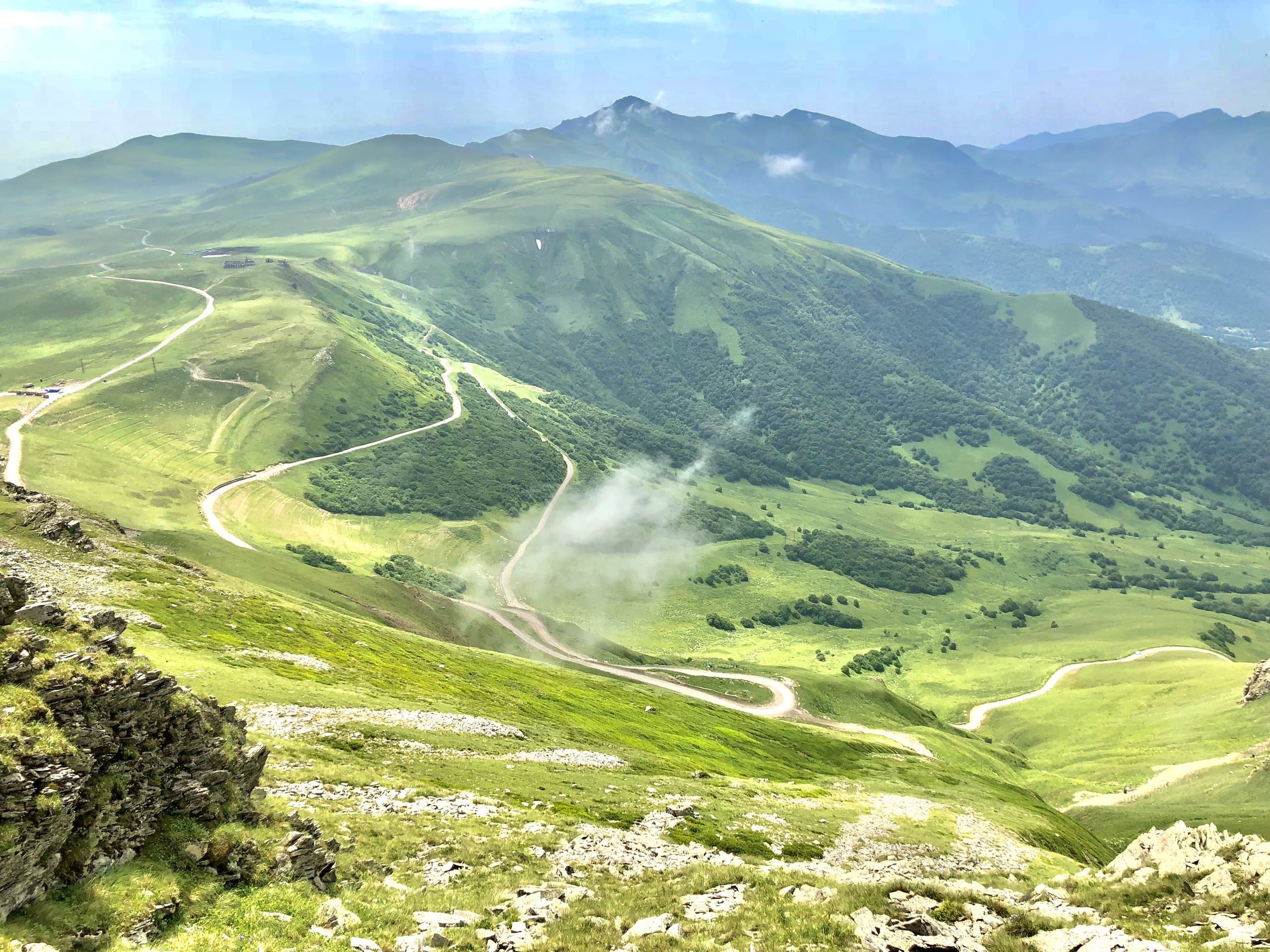 Wide green mountain landscape with visible ski runs.