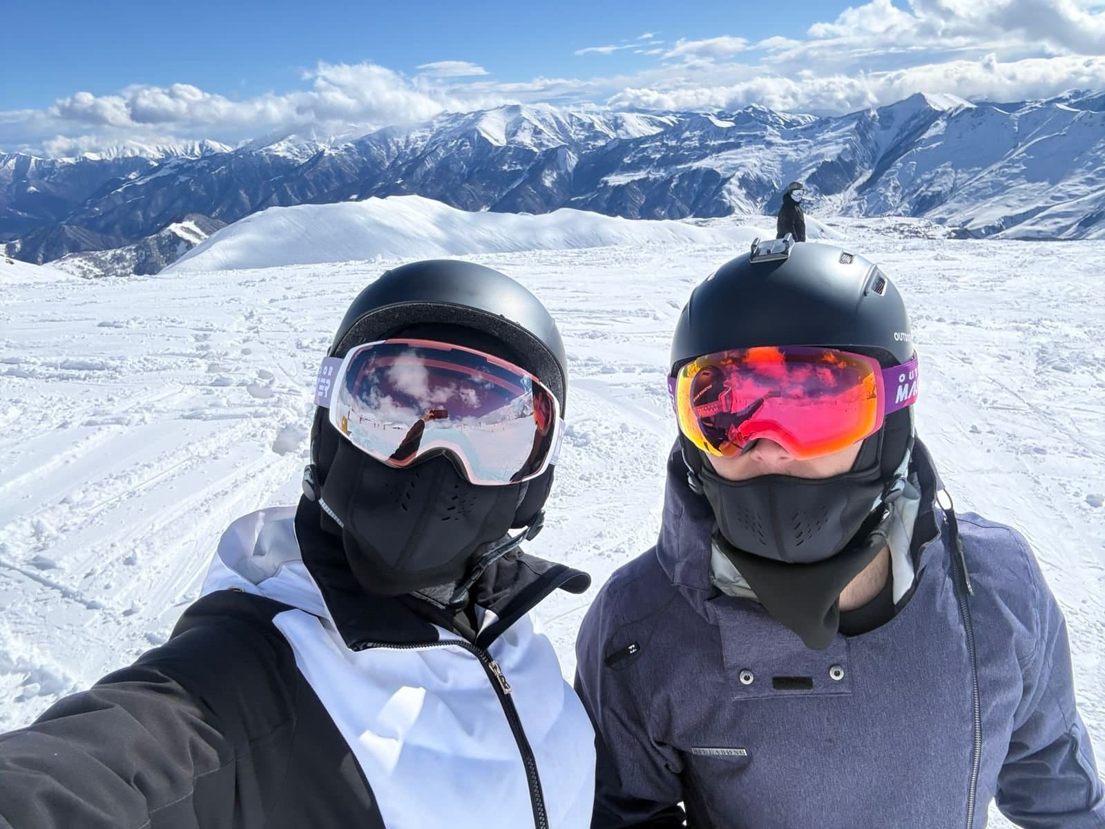Two skiers posing together on a snowy mountain.