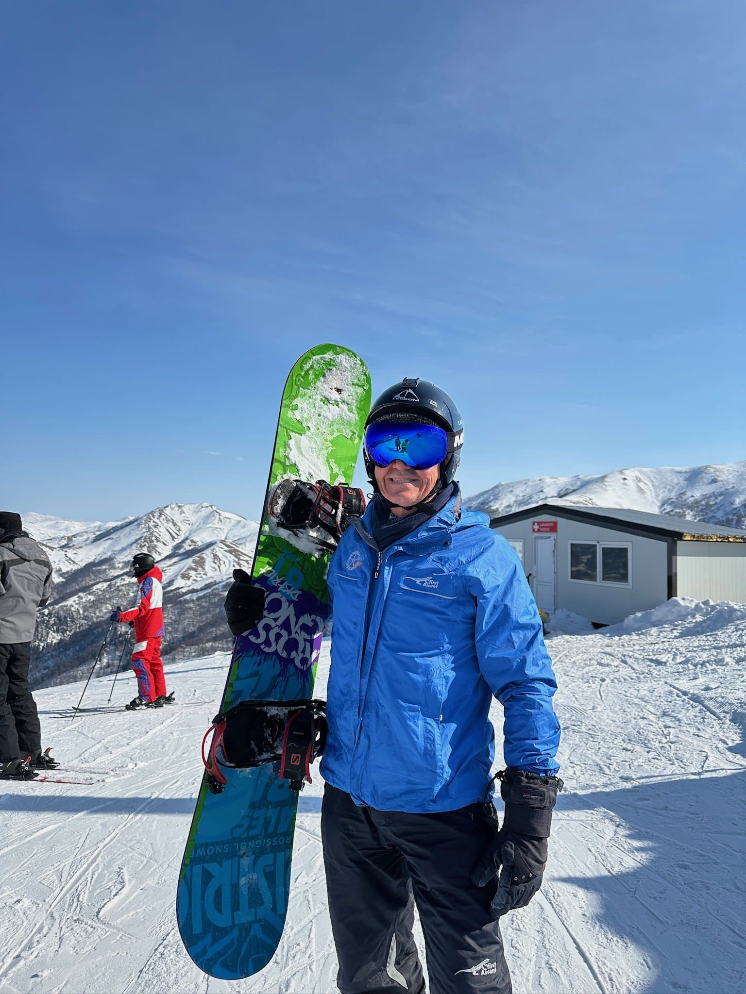 Snowboarder in winter gear holding a snowboard.