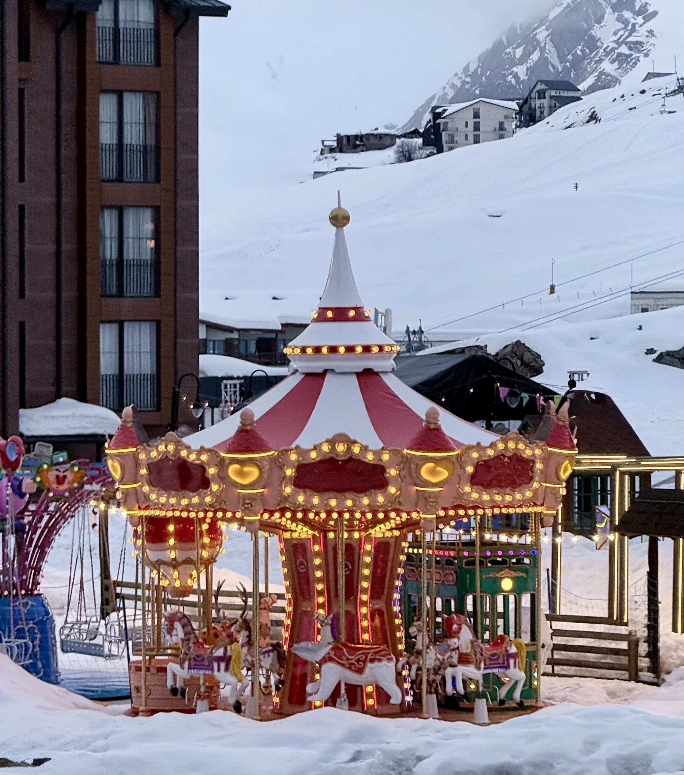Colourful carousel in a snow-covered ski resort.
