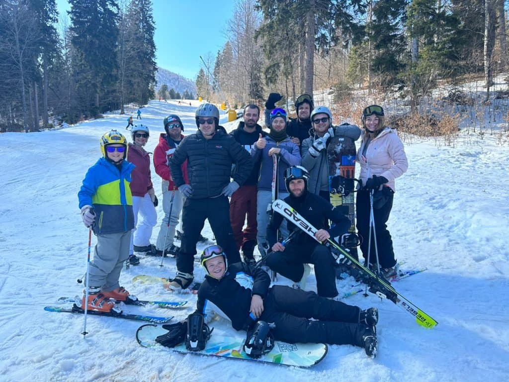 Group of skiers posing together on the snow.
