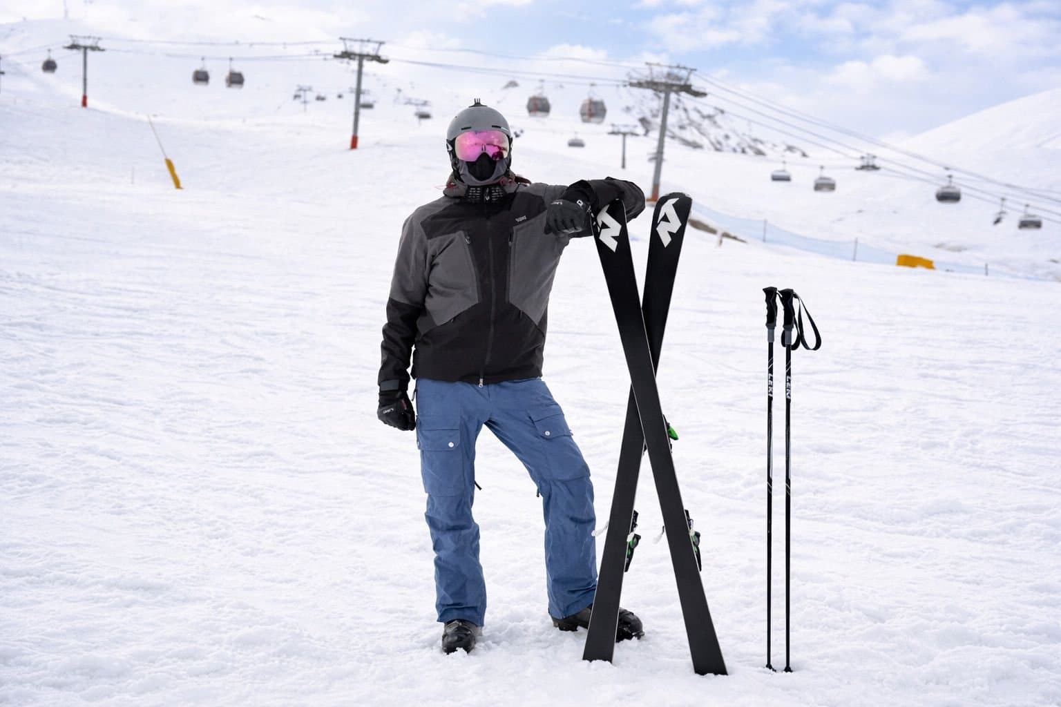 Skier with skis and poles on a snowy slope.