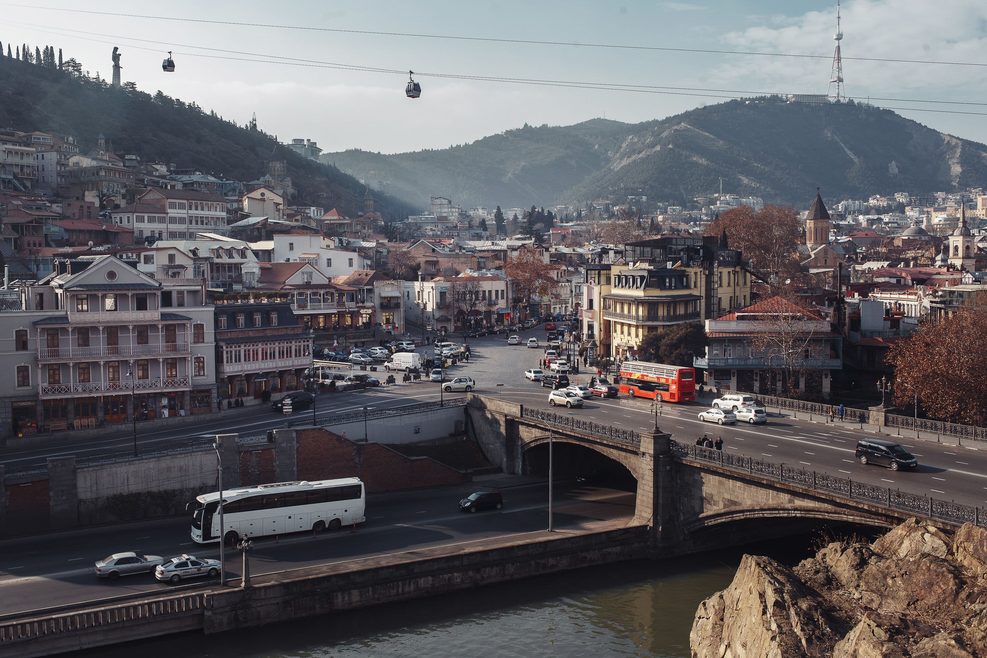 Tbilisi cityscape with the Kura River, bridge and cable cars