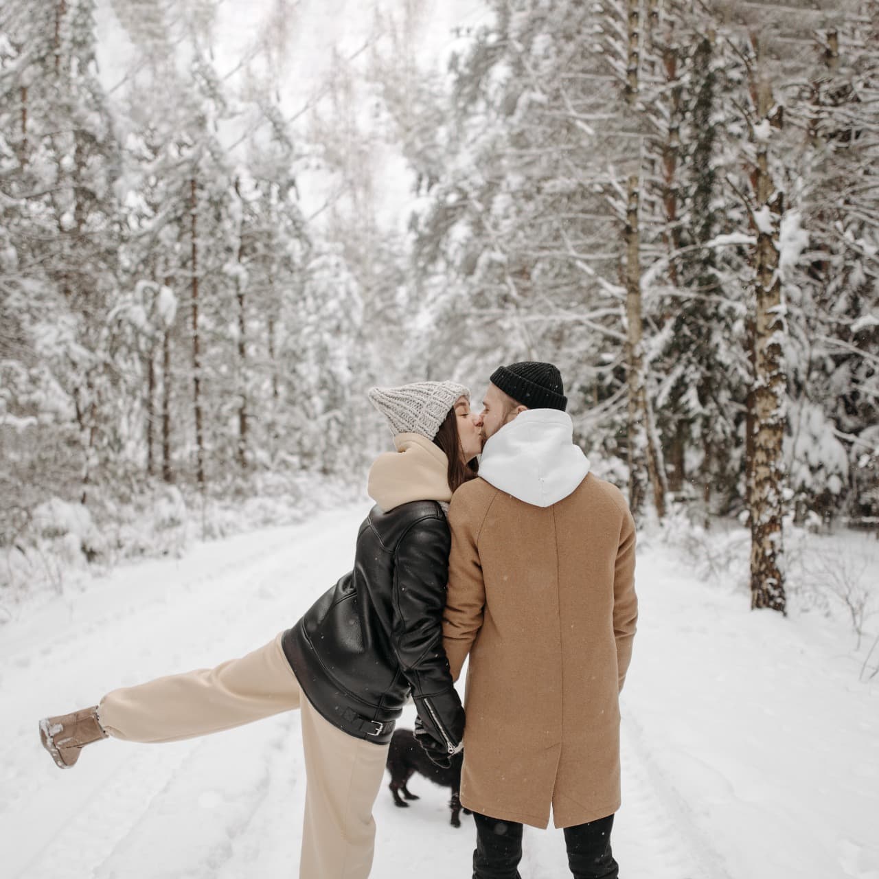 Couple kissing in a snowy forest