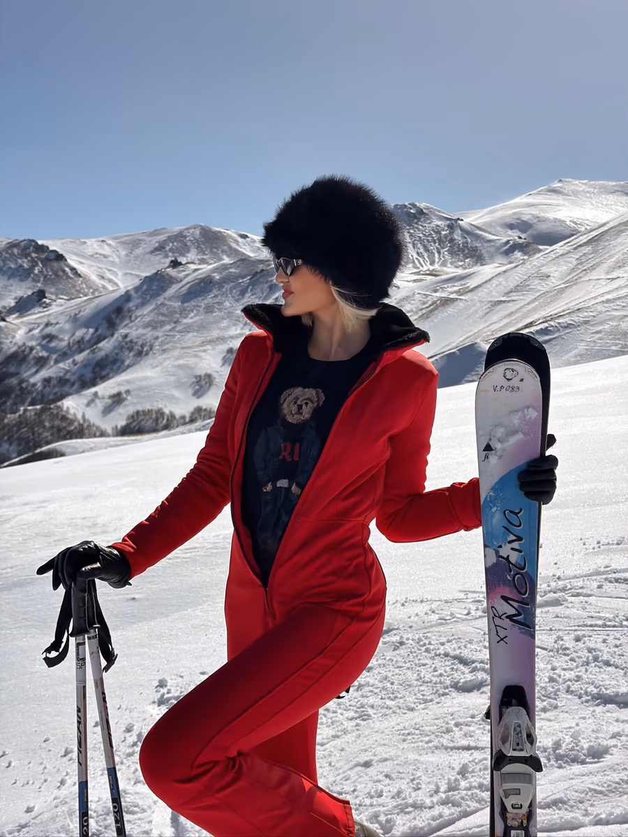 Amike Oosthuizen holding skis on a snowy mountain in Georgia
